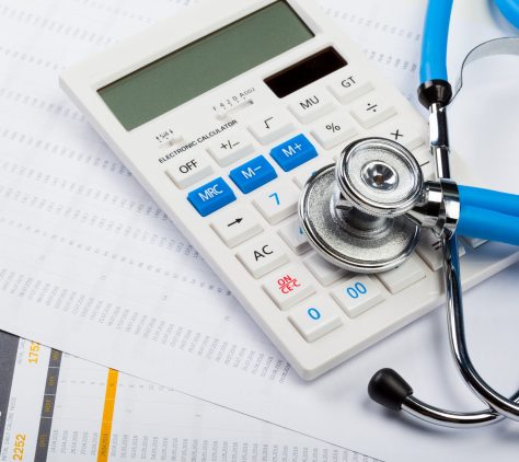 Health care costs. Stethoscope and calculator